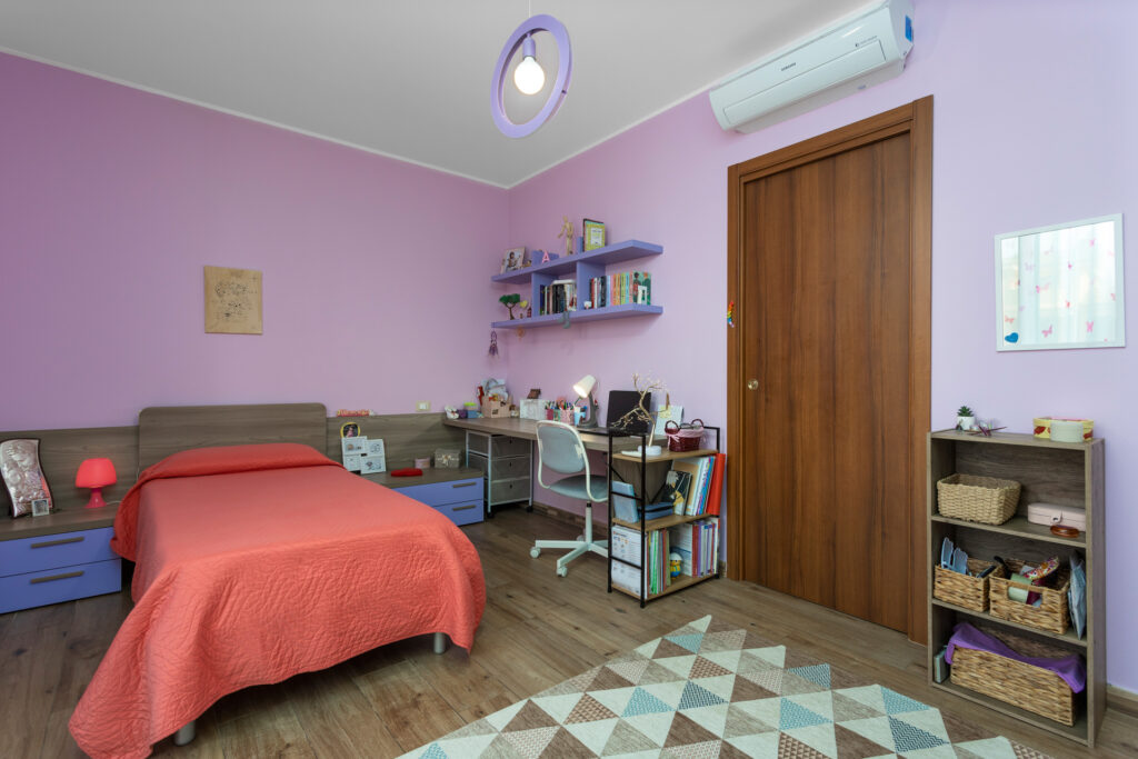 Ampia cameretta, luminosa ed essenziale con scrivania, letto da una piazza e mezzo, in appartamento a Milano